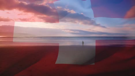 Composición-Digital-De-Ondear-La-Bandera-Suiza-Contra-Un-Hombre-Caminando-Por-La-Playa