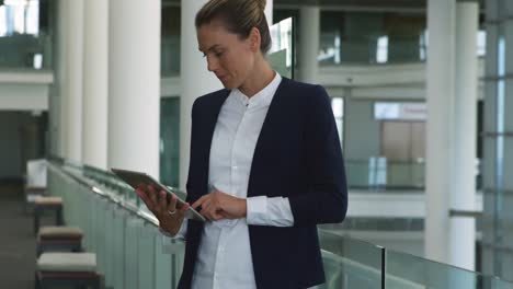Businesswoman-using-tablet-in-modern-office-building