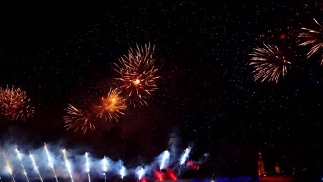 fuegos artificiales coloridos festivos e iluminación en el cielo oscuro con un hermoso reflejo en el agua. velas escarlata de vacaciones