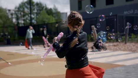 girl playing with bubbles in front of a building