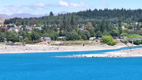 aerial view of tourist attraction of small church on lakefront lake tekapo, new zealand, sunny day