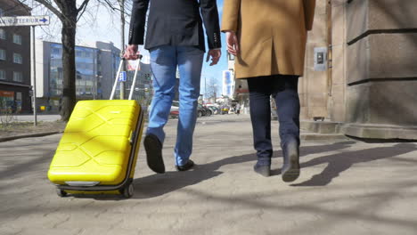 young couple with rolling bag in the city