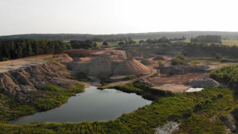 Drone-dolly-shot-of-dunes-and-pits-in-a-quarry-,-showing-contrast-between-nature-and-industry