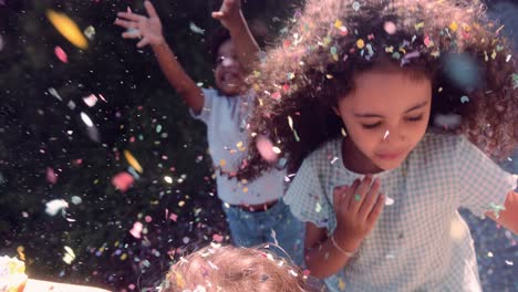 confetti falling on african-american little girl smiling outdoors