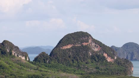 limestone cliffs and lush greenery under bright daylight in phang nga, thailand. the camera pans slowly across the serene landscape