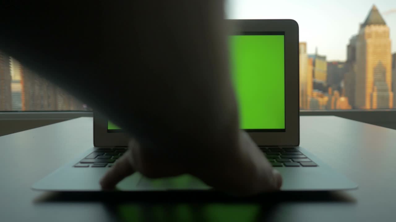 portátil de negocios con pantalla verde monitor de clave croma y fondo de paisaje urbano.