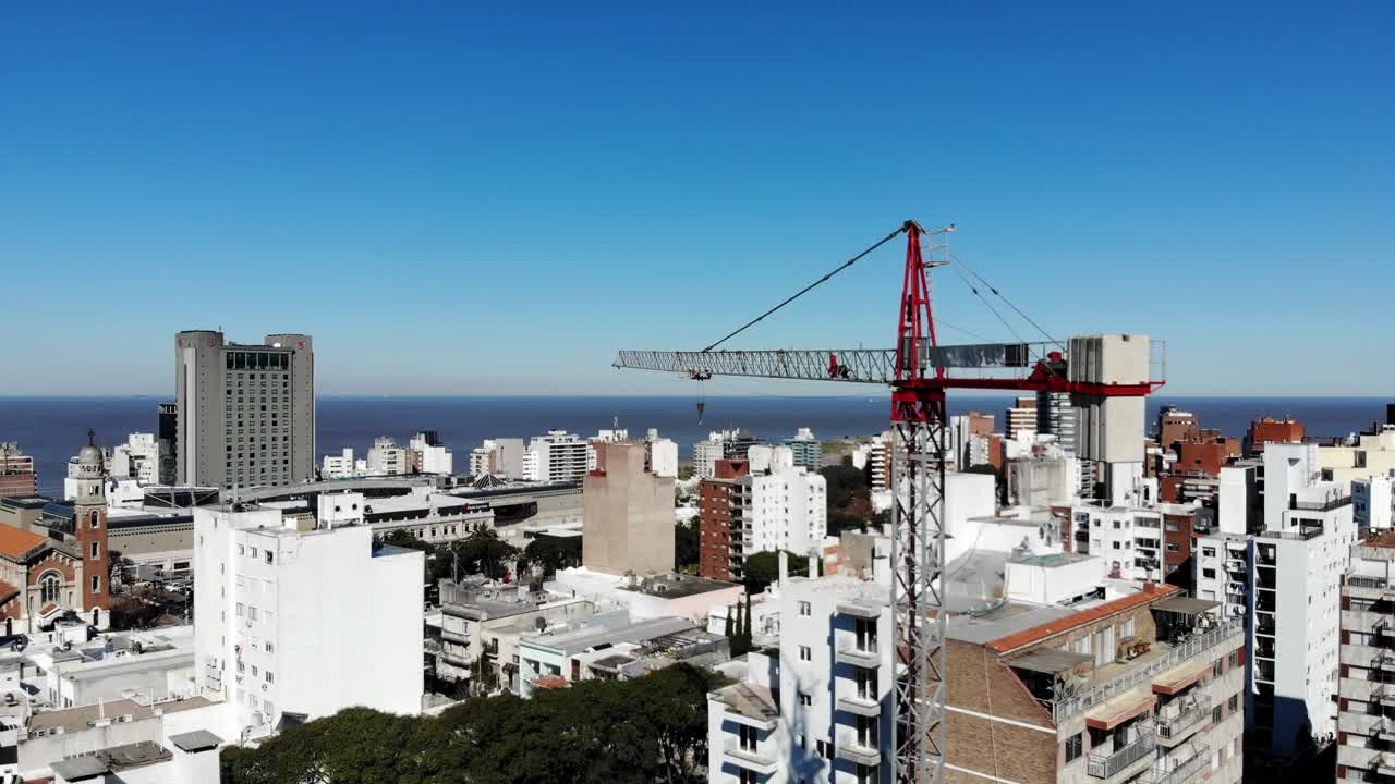 vista aérea de la ciudad de montevideo uruguay, con edificios, un edificio de grúas, el mar y el cielo despejado al fondo