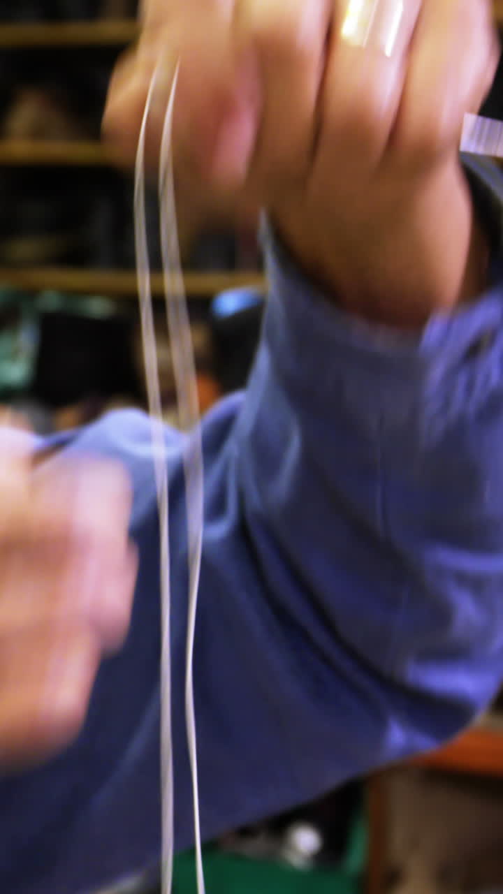 zapatero poniendo hilo en la aguja