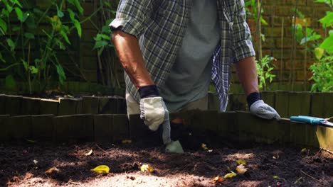 Senior-man-digging-in-the-soil-with-shovel