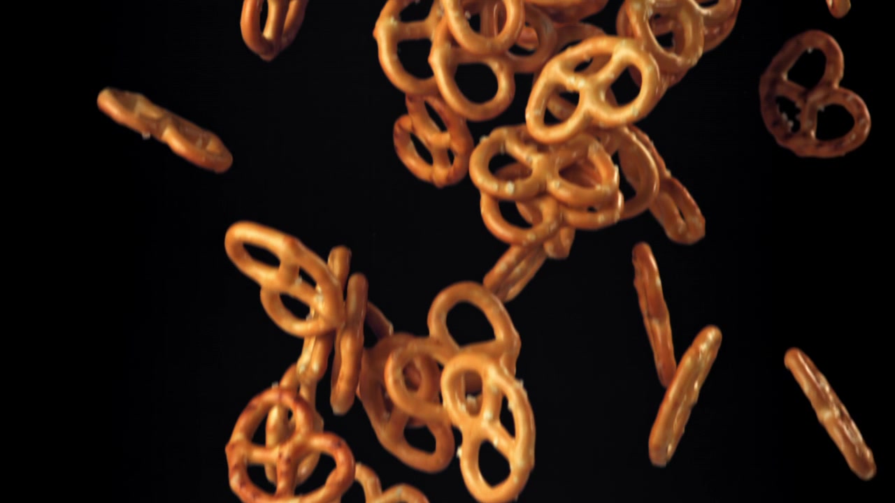 Pretzel salati che cadono al rallentatore su sfondo nero