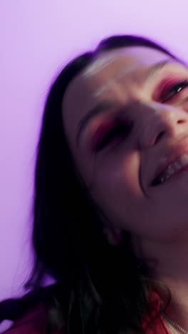 woman with pink makeup in purple studio