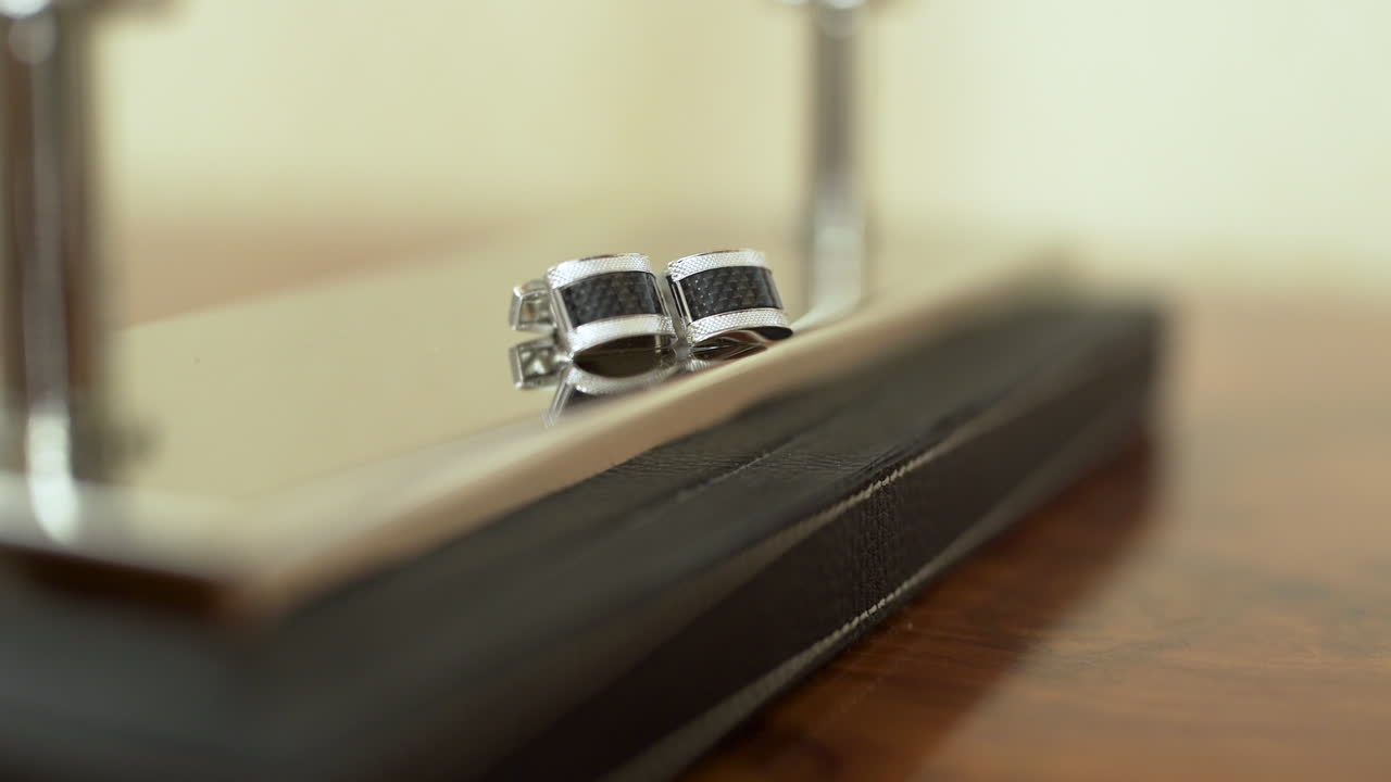 Abotoaduras de Prata Elegantes em uma Superfície Reflexiva