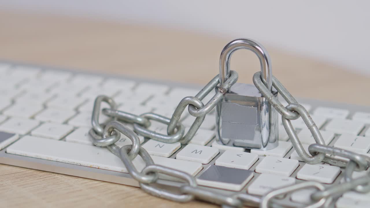 Cyber security concept Close-up of keyboard wrapped in heavy chains and locked with padlock