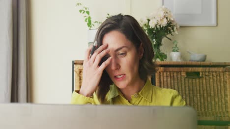 Midsection-of-caucasian-woman-on-laptop-video-call-working-from-home