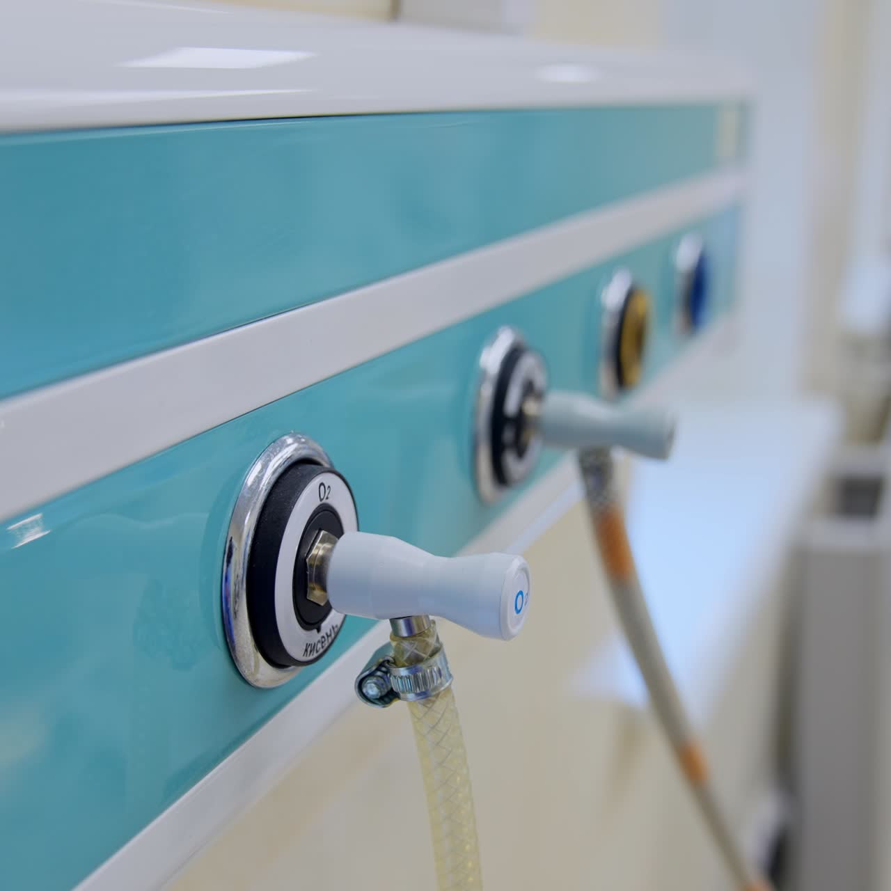 Blue panel with plugged tubes for oxygen supply to artificial lung ventilation apparatus in surgical room. Close up. Blurred backdrop