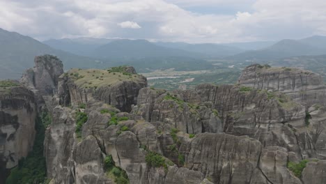 aerial over imposing rock monoliths reveals historic kalampaka town, greece