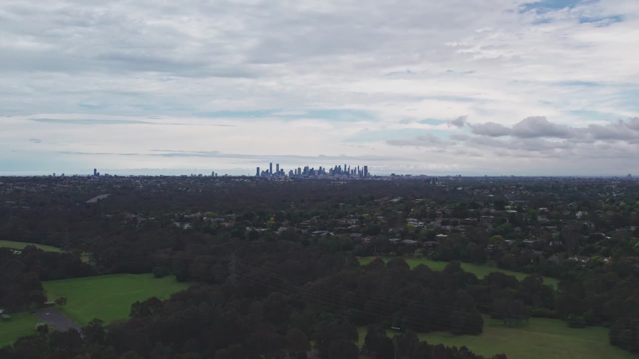 Aerial view over Bulleen Park with the Melbourne city in the distance. Victoria, Australia. December 2023.