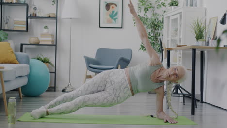 senior woman doing side plank exercise at home
