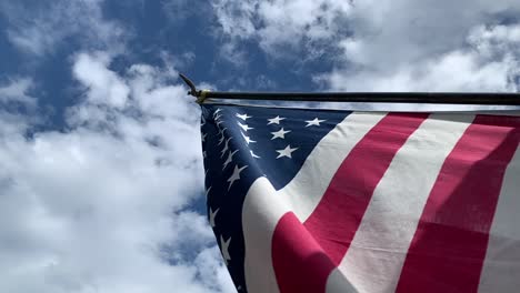 Eine-Wogende-Amerikanische-Flagge-Unter-Einem-Sonnigen,-Bewölkten-Himmel