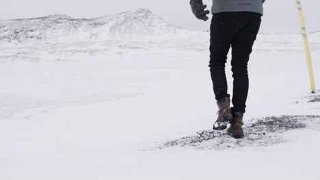 young male traveler walking through blizzard in slow motion