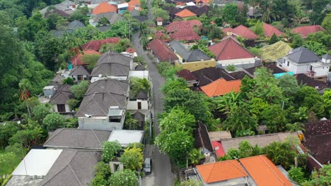 motorbike-driving-in-local-neighborhood-in-Umalas-Bali-on-cloudy-day,-aerial