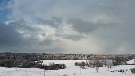 stunning aerial drone view of snowy winter forest under a dramatic cloudy sky with sunlight breaking through. winter scenery in countryside. clean environment.