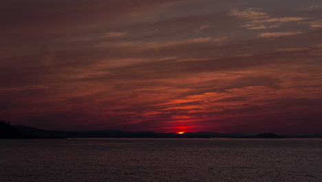 lapso de tiempo del humo de los incendios forestales que oscurece la puesta de sol sobre la orilla del lago superior