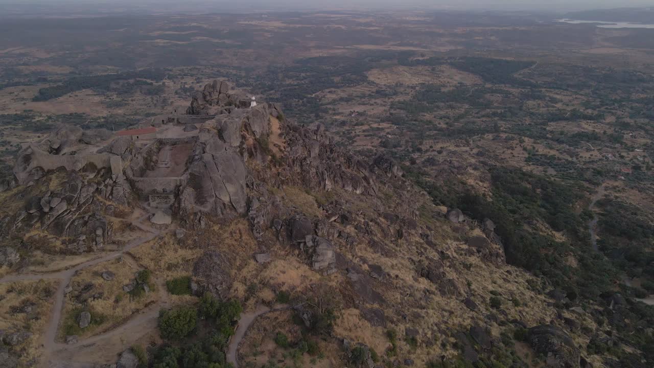 vista aérea de drones sobre las ruinas del castillo en la cima de la colina de monsanto al atardecer en portugal