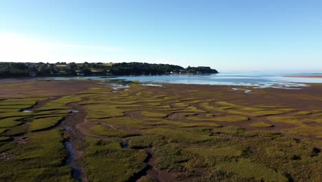 Aerial-view-Traeth-Coch-scenic-patterned-salt-marsh-moorland-rural-countryside-at-sunset