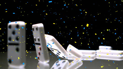 Animation of yellow and blue confetti over falling dominoes on black background