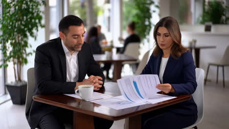 business professionals discussing documents over coffee