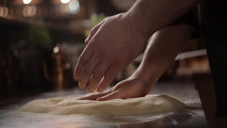 el chef amasa la masa de la pizza