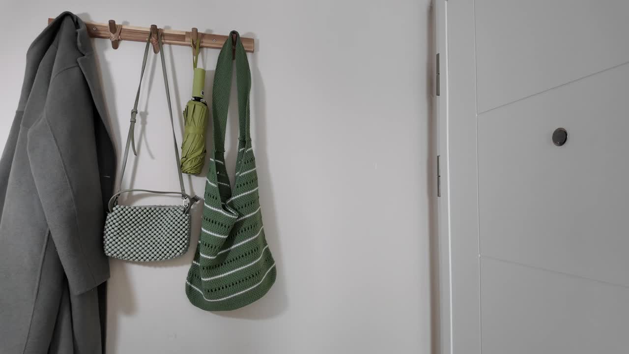 Coat, purse, and umbrella hanging on a wall