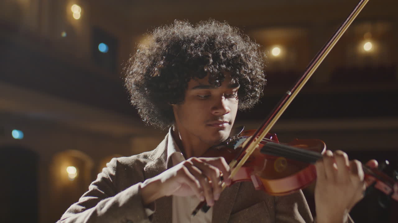 African American Musician Playing Violin in Concert Hall