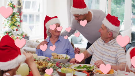 animación de corazones flotando sobre una feliz familia caucásica durante la cena de navidad