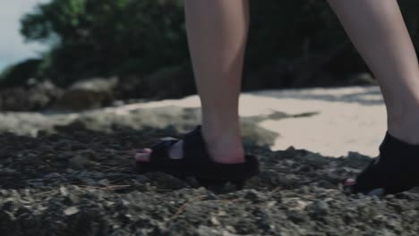 Girl-hopping-on-top-of-big-rocks-at-the-beach,-slow-motion