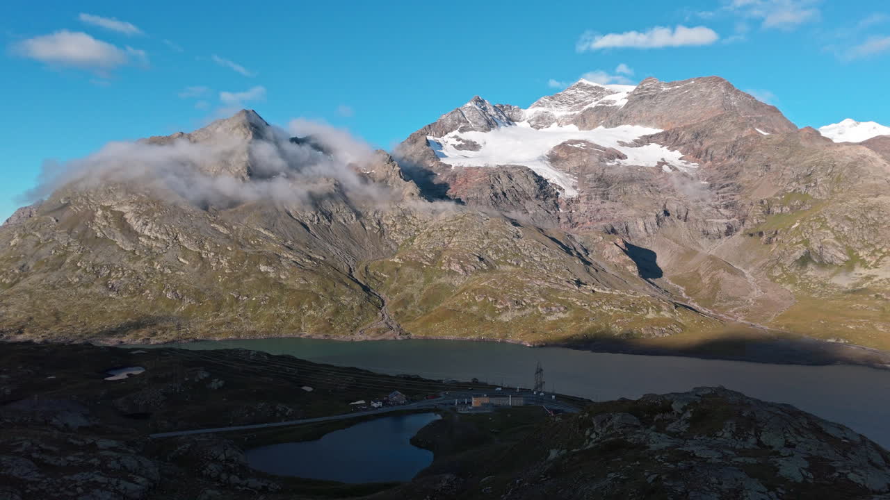Scenic mountain pass with lake, clouds, and peaceful landscape