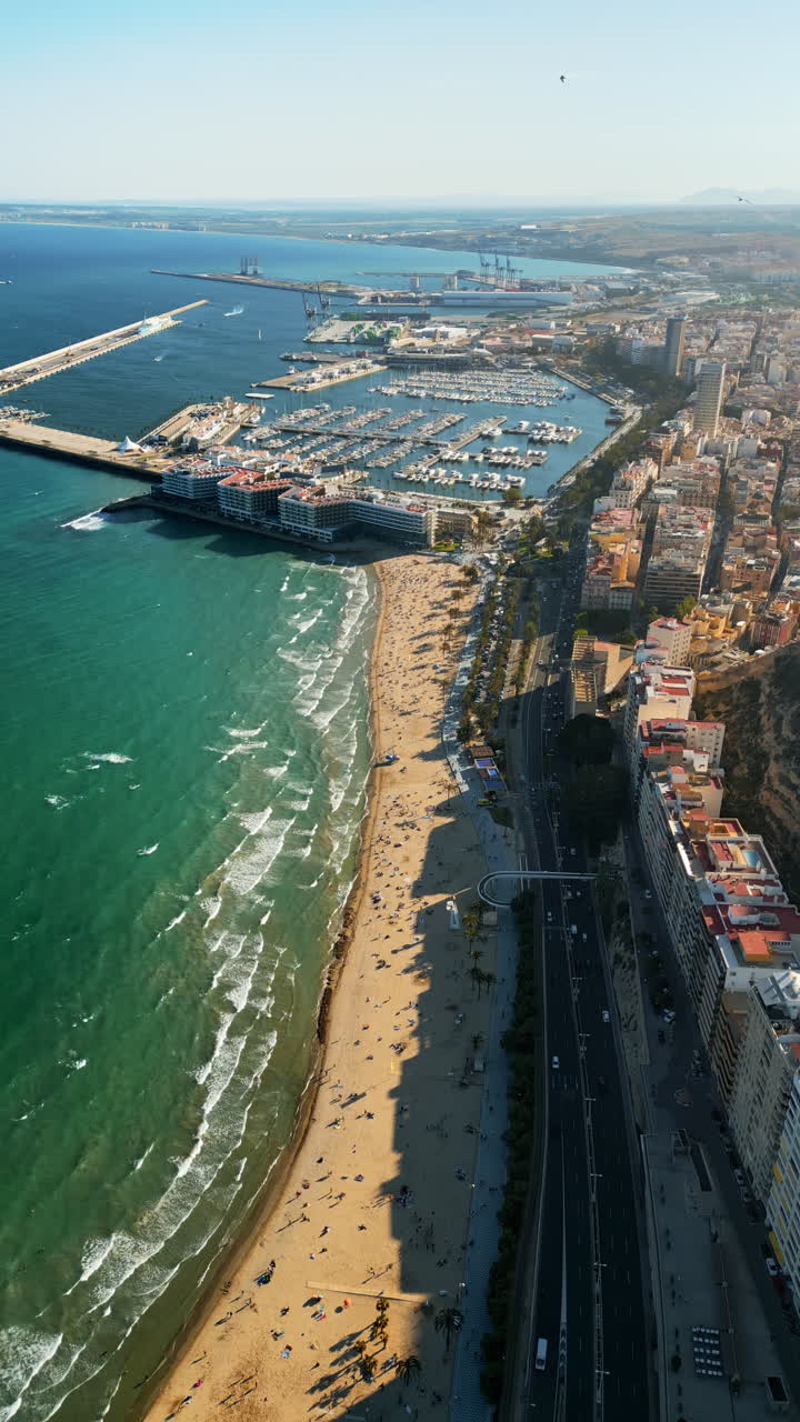 Vista aerea da drone del porto di Alicante e degli edifici della città alla luce del giorno. Verticale