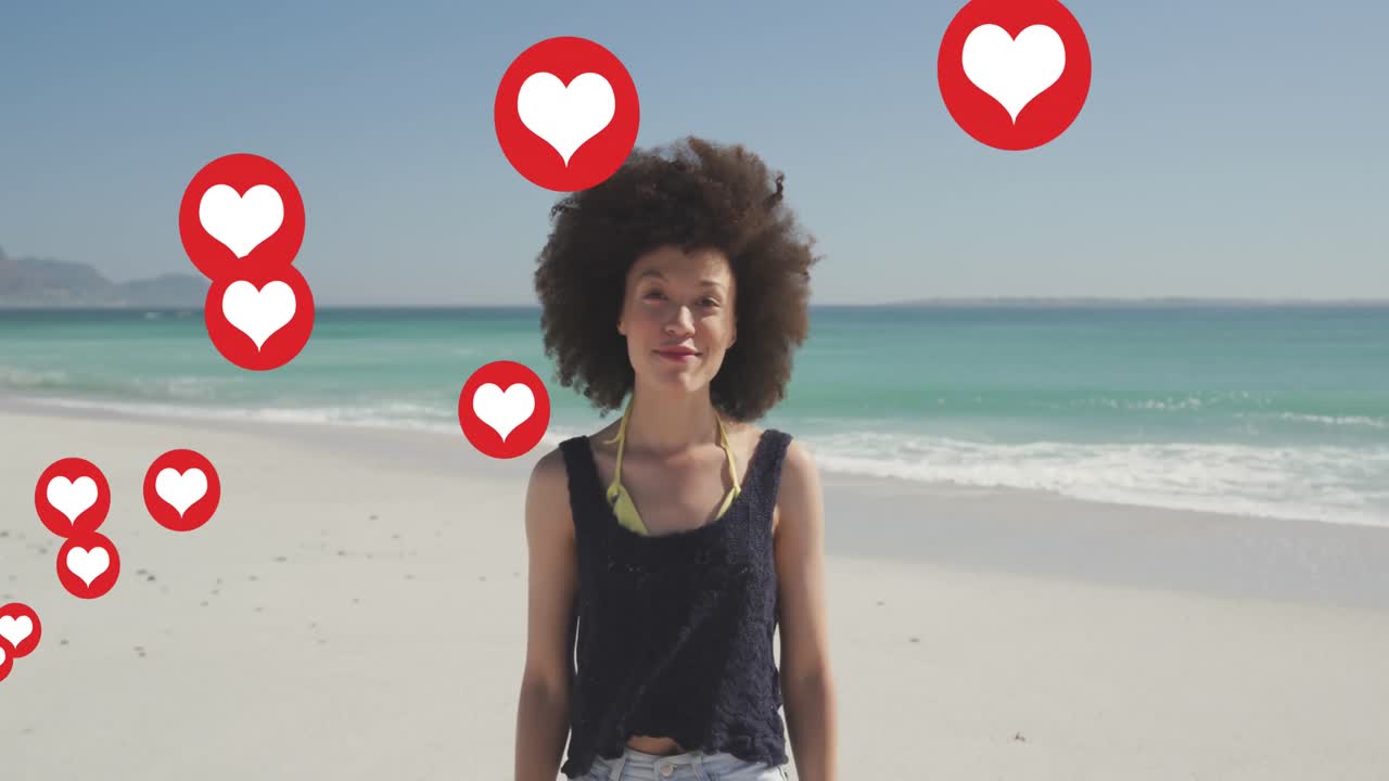 Múltiples iconos de corazón flotando sobre el retrato de una mujer afroamericana sonriendo en la playa.