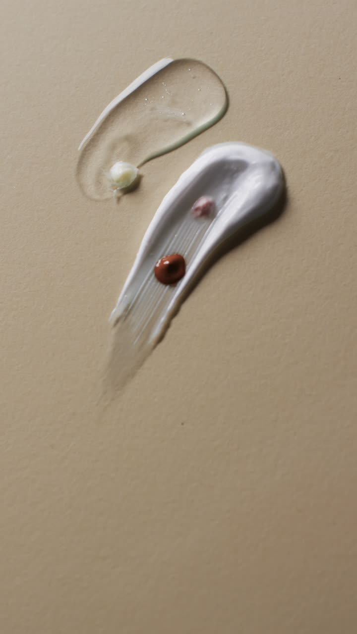 Vertical video of beauty product cream smudges with copy space on yellow background