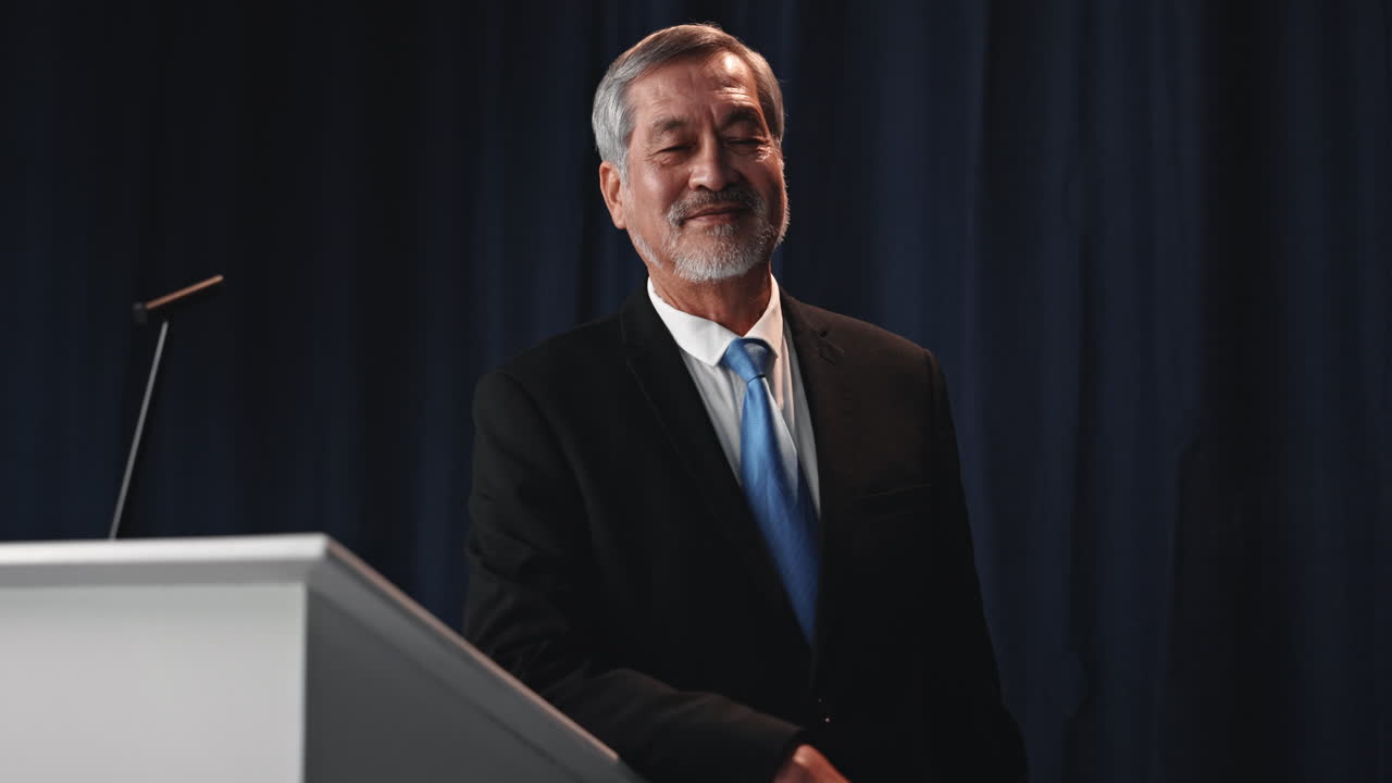 Asian Man Giving Speech at Podium