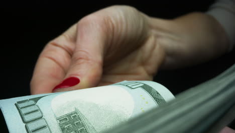 Woman-counting-cash-money-on-black-background.-Finance-and-cash-concept