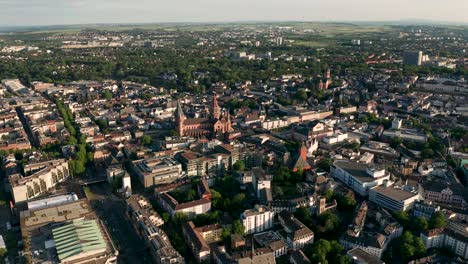 revealing shot of mainz at daylight with green tress the red dome and the rhine river at the end