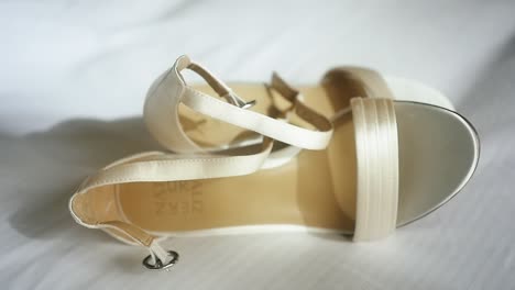 pretty off-white wedding shoes on white linen sheets