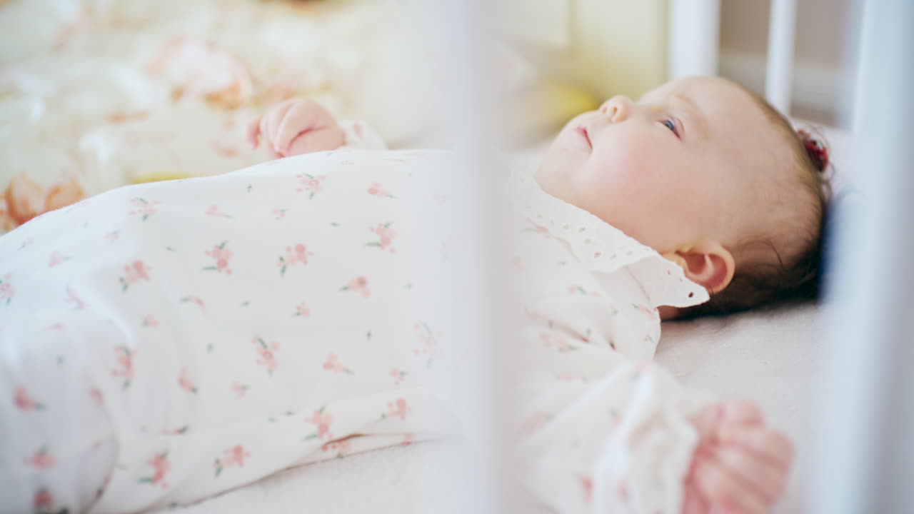 Primo piano di un bambino felice sdraiato nella culla, che sorride e guarda verso l'alto