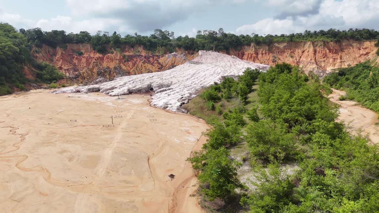 vista aerea di un enorme ghiacciaio di sale bianco incastonato tra una cava rossastra e la fitta foresta pluviale verde del Congo, Africa