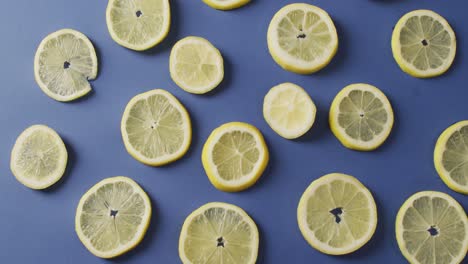 video of slices of lemon lying on blue background