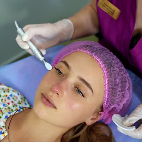 cosmetology. woman in clinic receiving stimulating electric facial treatment. closeup of young female face during microcurrent therapy
