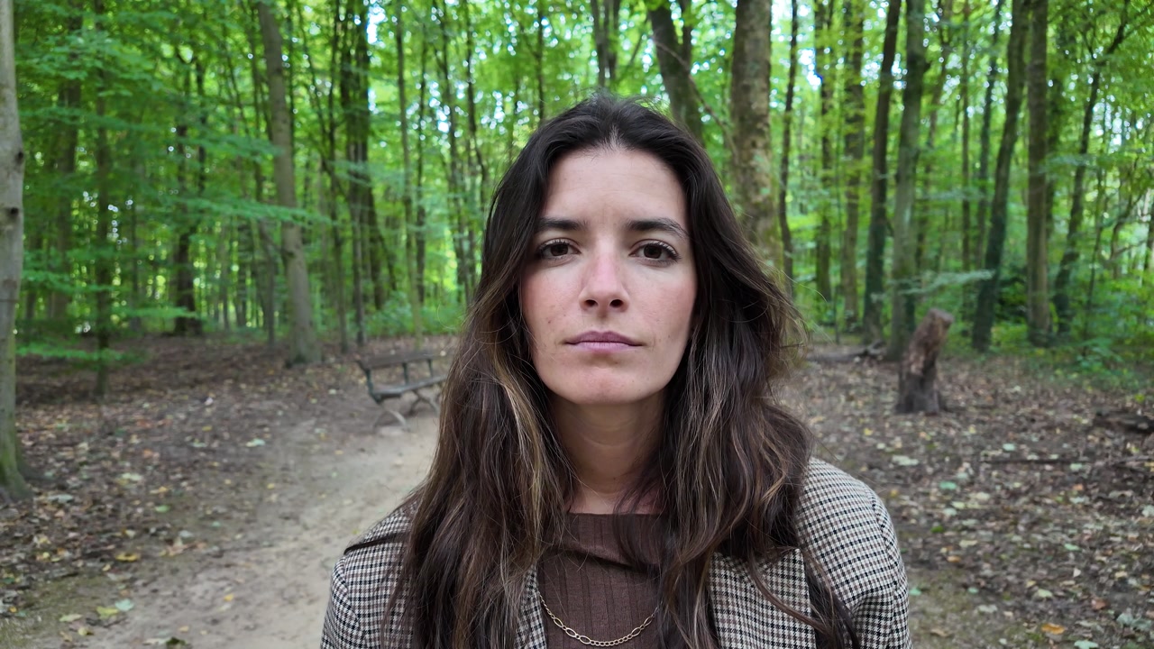 Portrait of a young female in woodland environment surrounded by trees