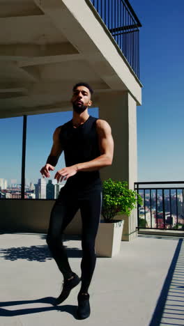 man dancing and posing on a sunny city rooftop